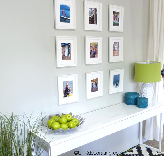 Hallway table placed under gallery wall made with summer vacation photos