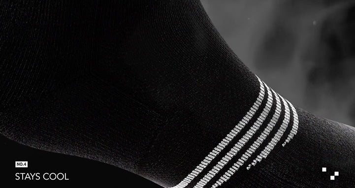 pic of a foot wearing a black sock with white stripes and there appears to be steam coming off it.