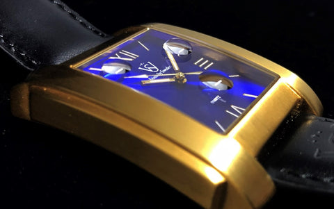 SÖNER LEGACY A Fyrkantig klocka i borstat guld med blå romersk urtavla - Närbild på fyrkantig klocka med safirglas
