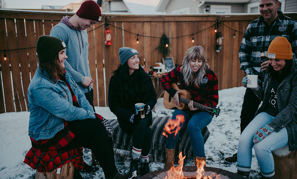 Kootz Collective group at campfire in toques, flannels and other Kootenay apparel