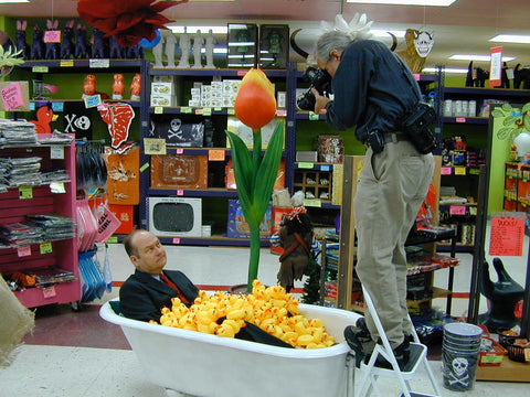 Mark Pahlow in a bathtub filled with Rubber devil ducks