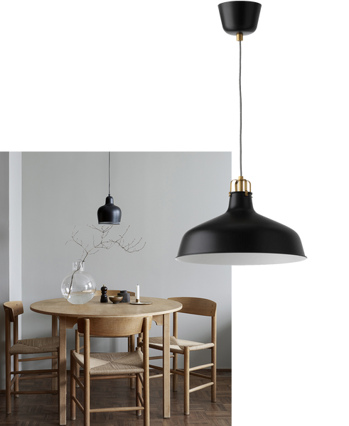 a minimal Scandi-style dining room with a round wooden table and a simple black pendant light above it
