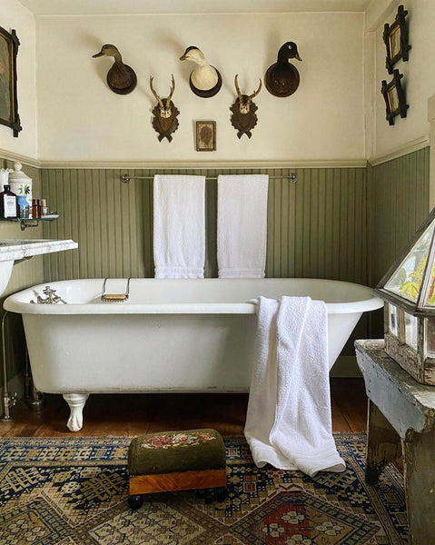 country bathroom with mint wood panelling and an antique rug - designed by James Coviello