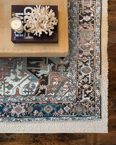 an antique Heritage rug layered over a neutral wool rug