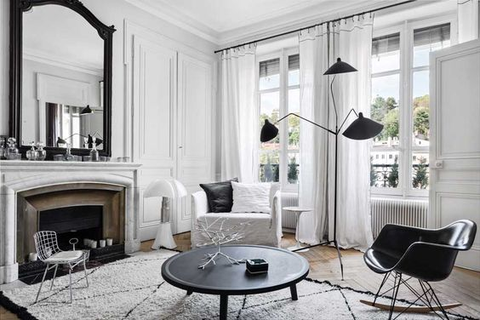 a bright white room with black accents, high ceilings and long linen curtains