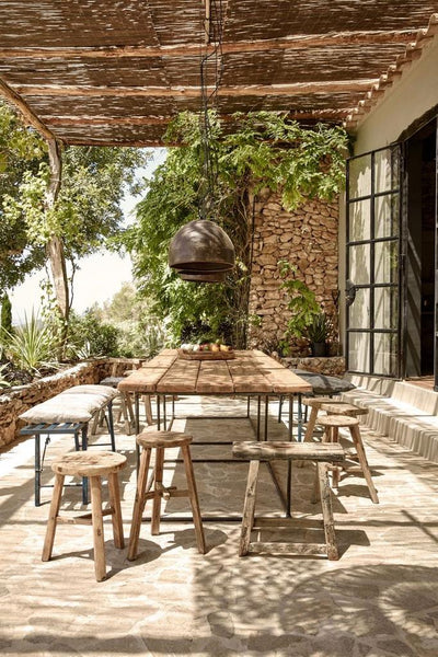 Gorgeous outdoor patio with woven sun roof and mismatched wooden stools