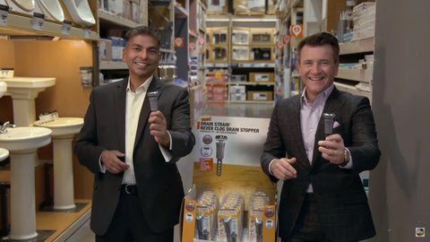 Naushad Ali and Robert Herjavec Holding a Drain Strain in a Store.