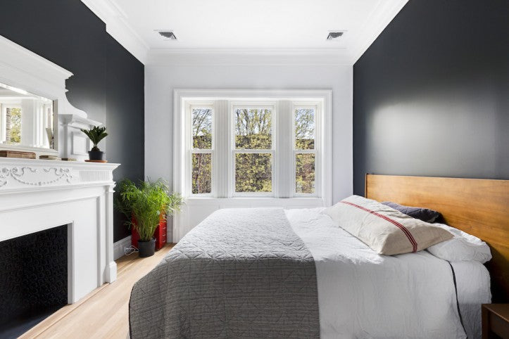 minimal grey bedroom with fireplace and bay window