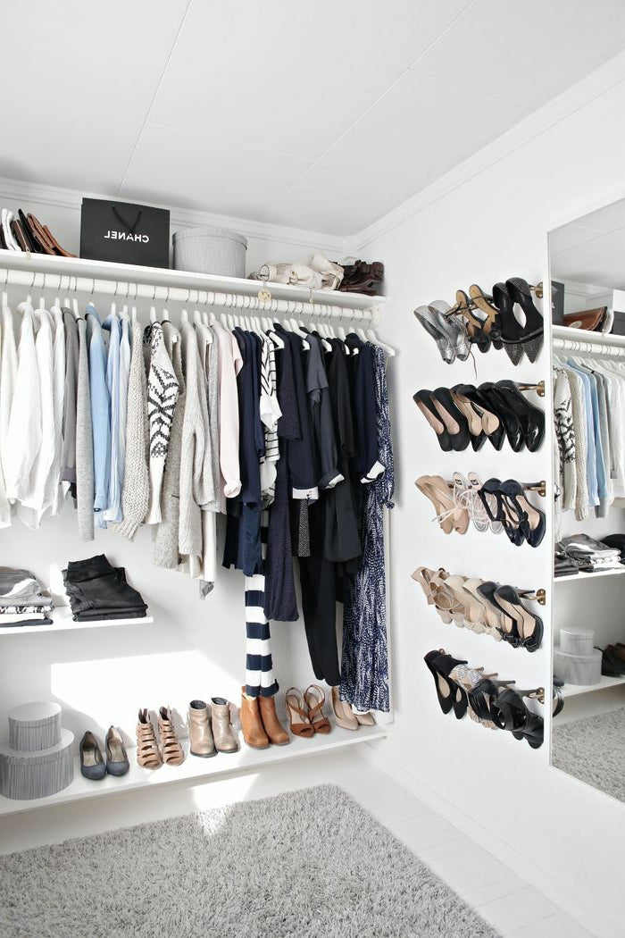 beautiful walk in open closet in white clothes rail