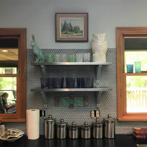 handmade tiles installed in a kitchen with rabbit and owl statues 