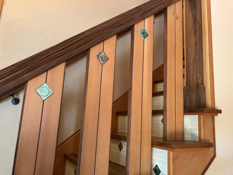 two tone handcrafted wooden stair railing with inlaid handmade tiles depicting aspen leaves in multiple colors