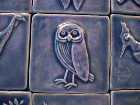 handmade owl tile in blue glaze surround by other handmade tiles