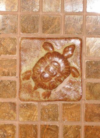 Fireplace surround with hand-made ceramic turtle tile