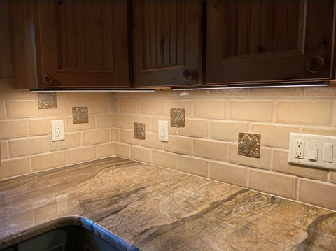 handmade maple leaf tiles installed in a kitchen backsplash