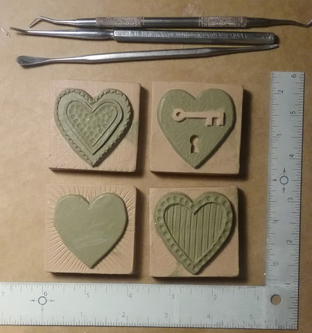 sculpting handmade tiles with heart designs, two inch by two inch size