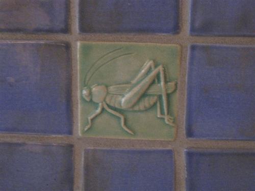 grasshopper art tile installed with handmade field tiles