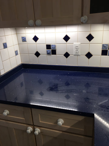 blue handmade animal tiles installed in a kitchen backsplash