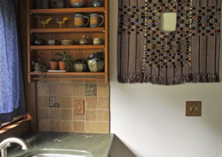 art tile installation in a kitchen with art pottery on display