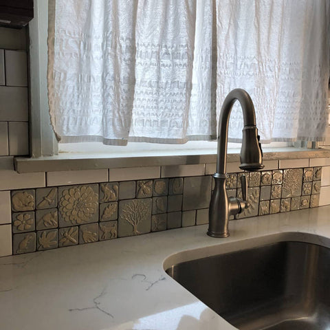 close up of periwinkle glazed handmade tiles in a kitchen sink backsplash