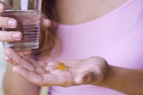 Woman taking a CBD capsule