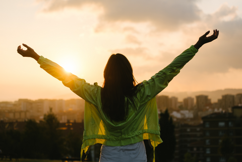  Female athlete raising arms to the sky after exercising