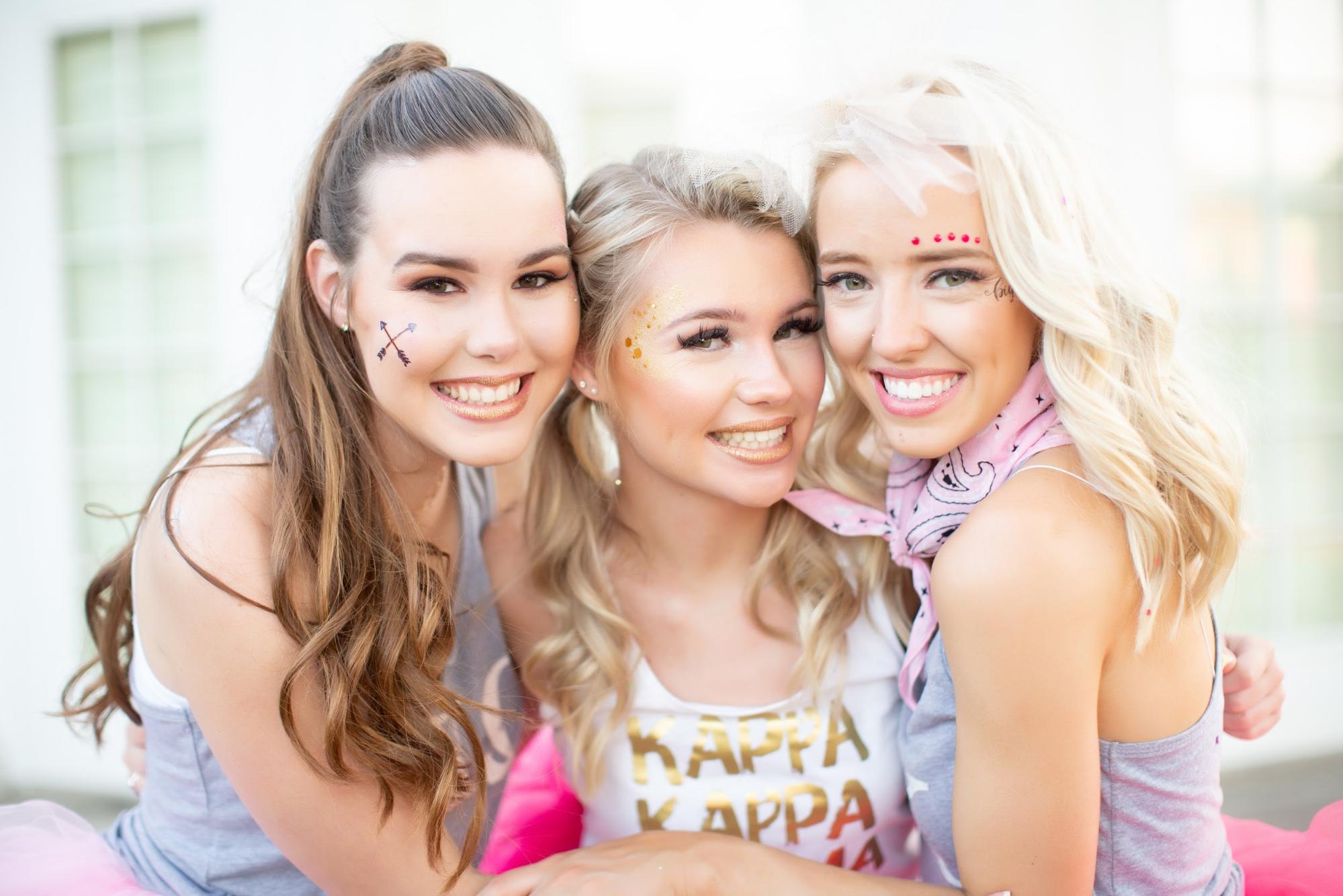 Three sorority sisters holding each other close while posing