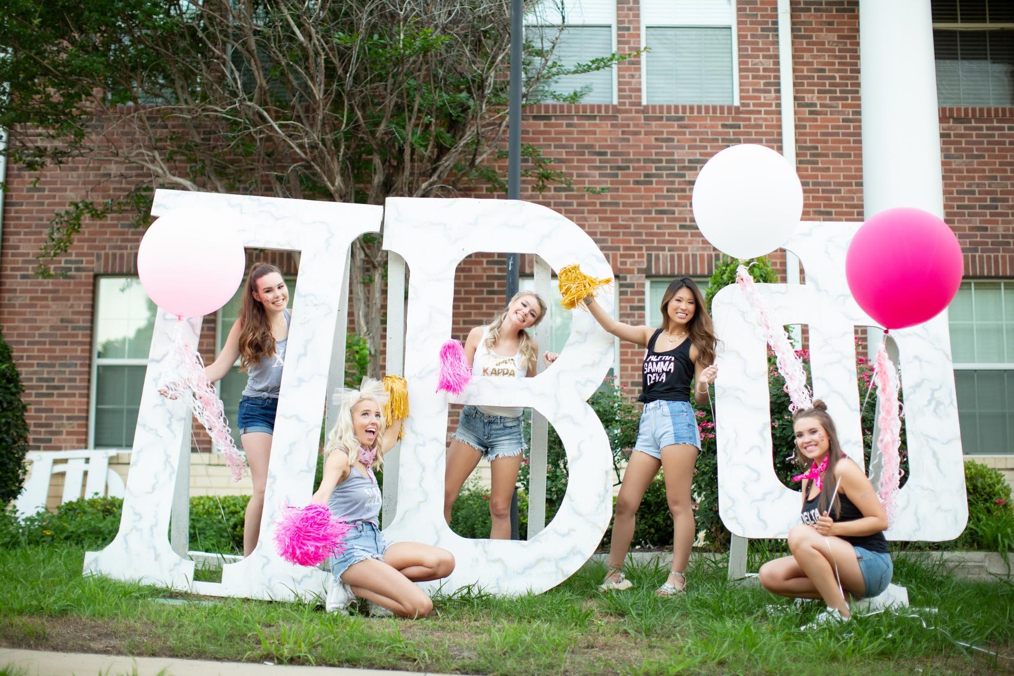 Sorority posing with large greek letters