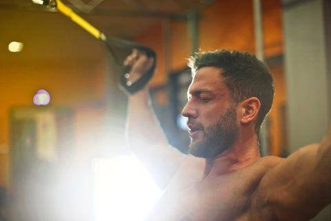 Man pulling on two cables at the gym