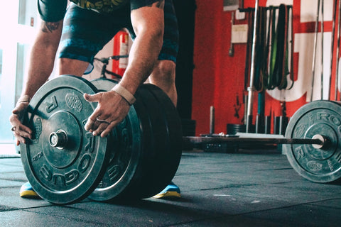 Man adding additional plates to the barbell