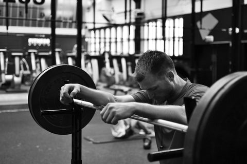 Man resting on his barbells