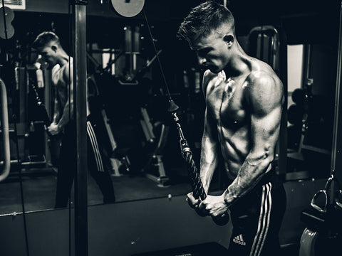 Man working at the gym machine to workout