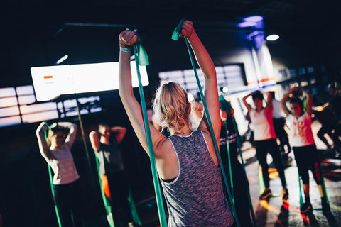 Woman in a fitness class pulling on cables