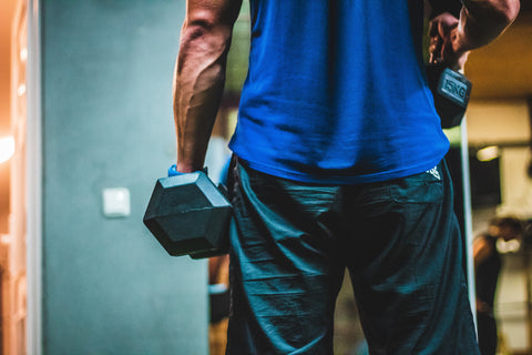 Man in blue holding a dumbbell
