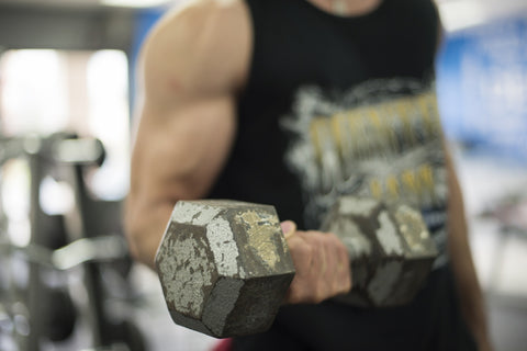 Muscled man working out with a dumbbell
