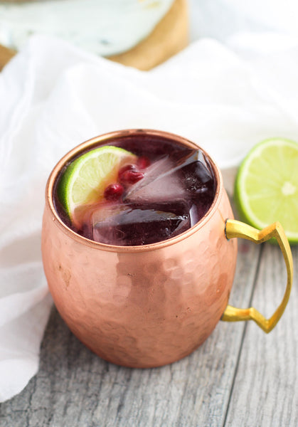 Moscow Muled copper mug filled with liquid cranberries and sliced lime