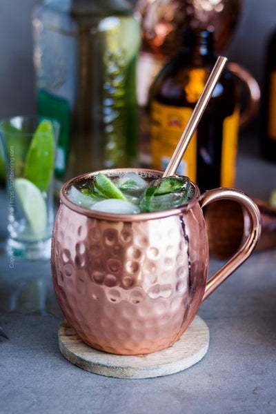 copper mug with a straw filled with liquid ice and lime
