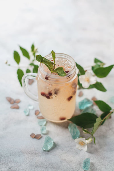 clear glass filled with peachy white liquid cranberries and mint leaves