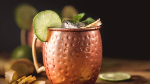 Moscow Muled copper mug filled with ice and citrus lime wedged on its rim