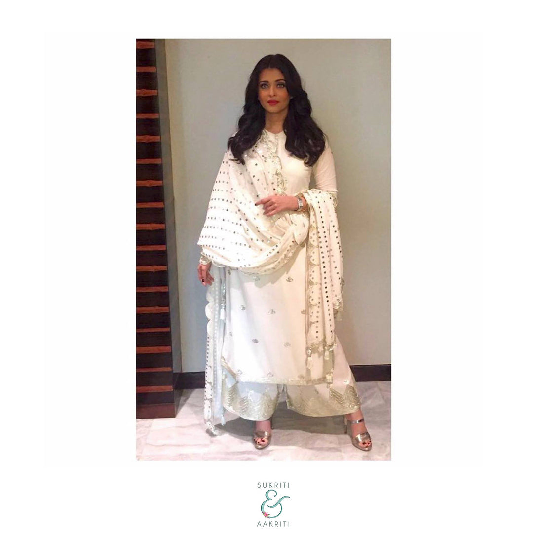 Aishwarya Rai Bachchan wore a white churidar and kurta with a matching embroidered dupatta (all) from Sukriti and Aakriti 