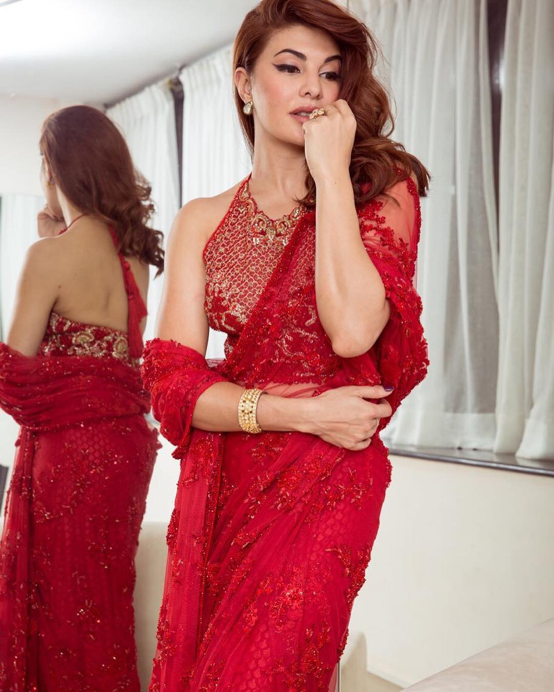 Jacqueline Fernandez fabulous in a bright red netted embroidery saree from Faraz Manan,paired with a embroidery backless blouse