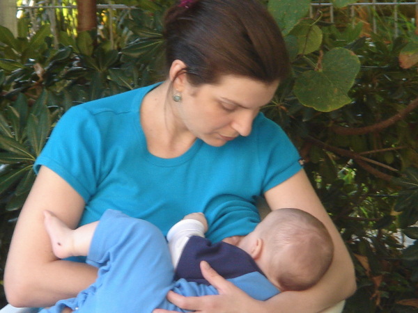 Mother breastfeeding baby outdoors