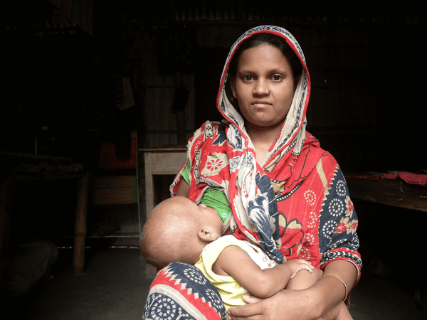 Woman breastfeeding baby in chair