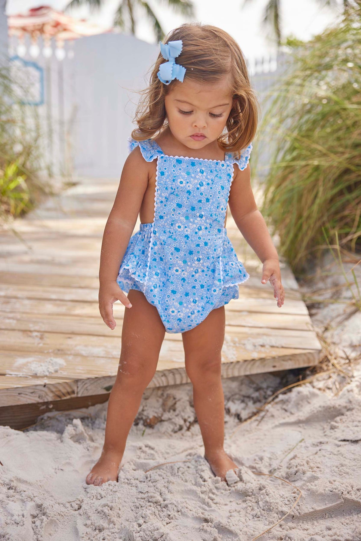 classic childrens clothing girls blue and white floral sunsuit with ruffled straps and white ric rac trim