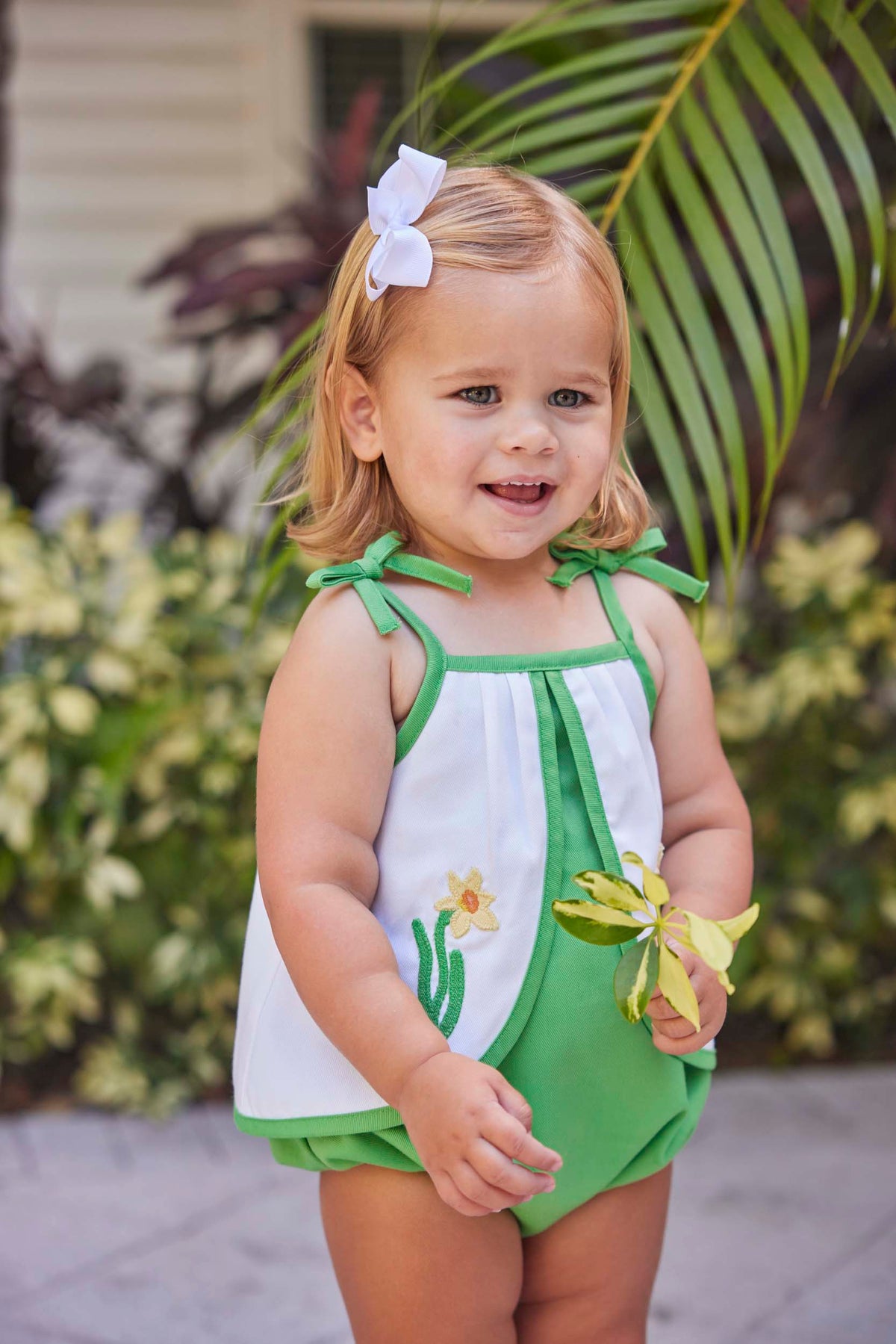 classic childrens clothing girls pink and white sunsuit with daffodil applique and bows on sleeves