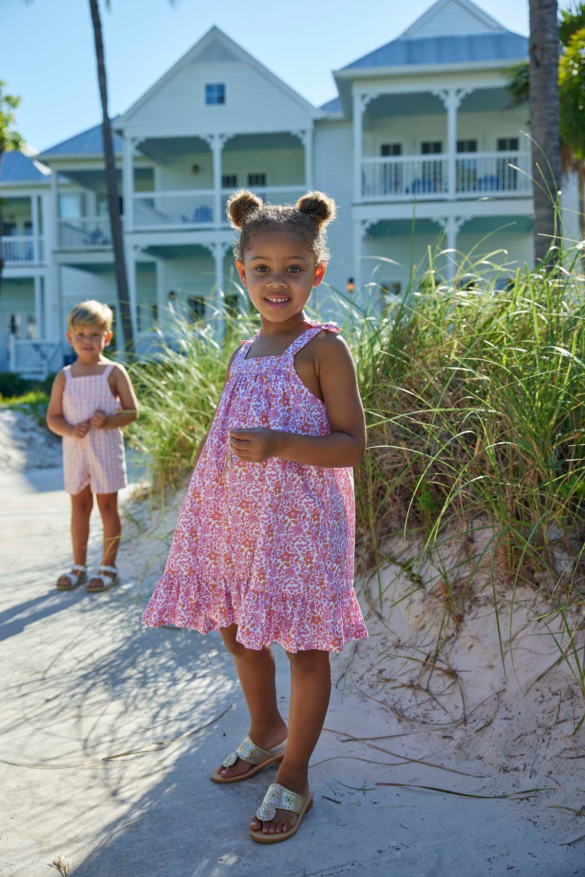 classic childrens clothing girls strapless dress in pink and orange floral print with bows on the sleeve straps