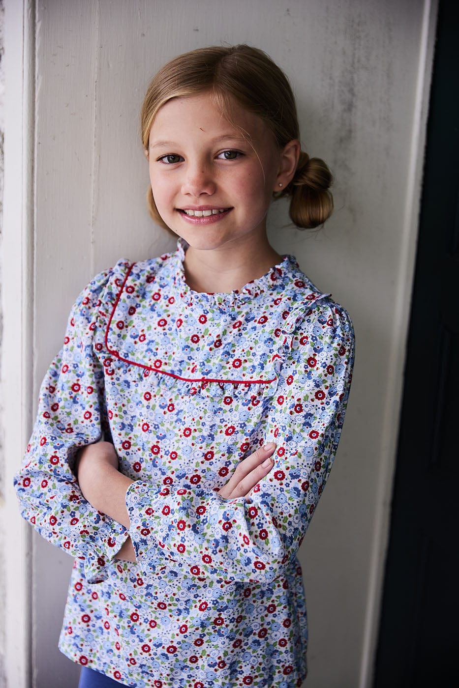 classic childrens clothing girls blouse in blue and red floral pattern with ruffles around neck and sleeves and red piping detailing