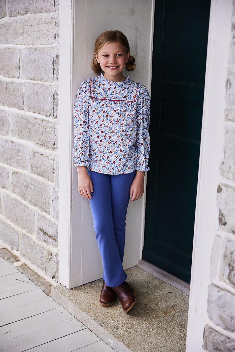 classic childrens clothing girls blouse in blue and red floral pattern with ruffles around neck and sleeves and red piping detailing