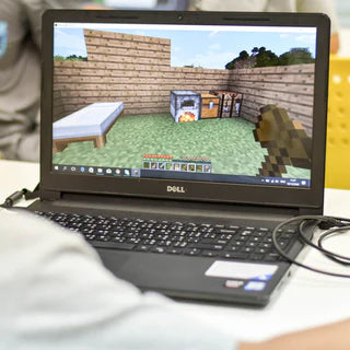 boy playing Minecraft on laptop