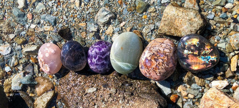 Colorful Polished crystals lined up on lake with rocks