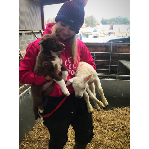 Anna Truesdale holding a puppy and a lamb on her farm